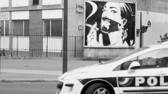 Monsieur Qui completes his poster street art installation moments before the cops arrive