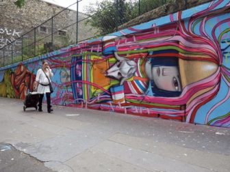 Graffiti artist Seth paints a little French girl in a traditional folk dress in this street art mural in Paris, France